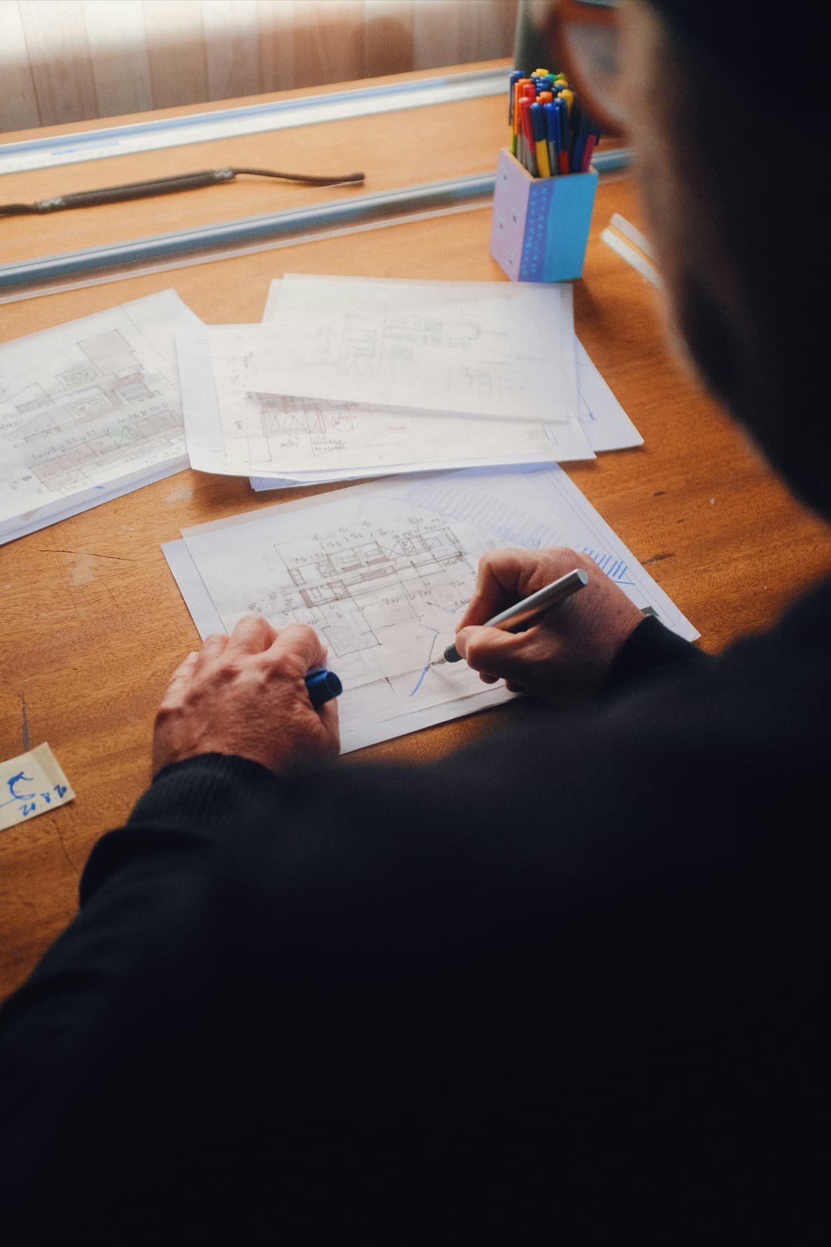 Architect sketching over blueprints during an early design review