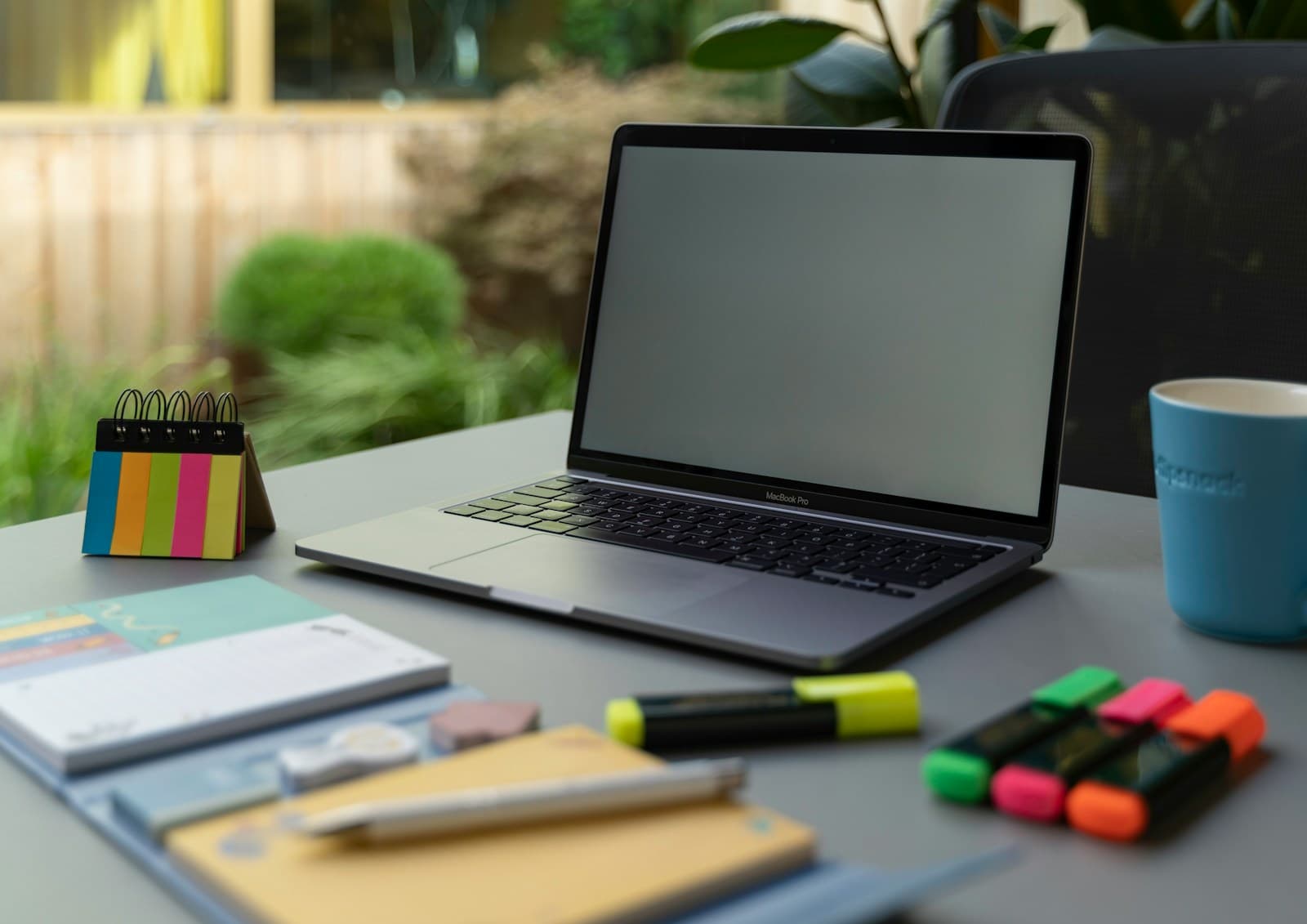 Laptop and notebook on a desk used to review project and billing data